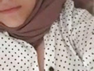 Junge Frau zieht sich aus und zeigt ihre Brüste