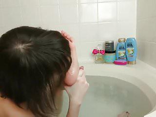 Junges Girl leckt ihre füsse im Badezimmer